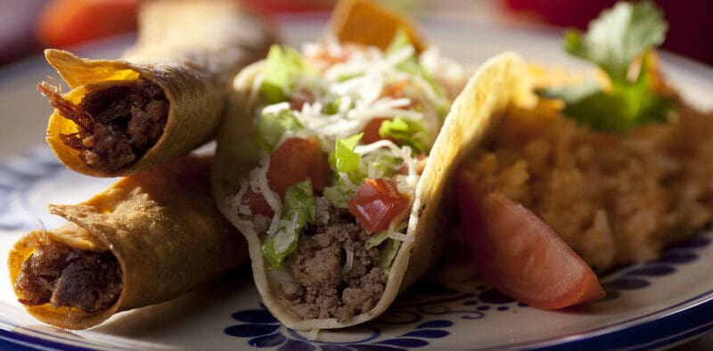 Flautas and ground beef tacos served with rice and garnish at El Paso Mexican restaurant.
