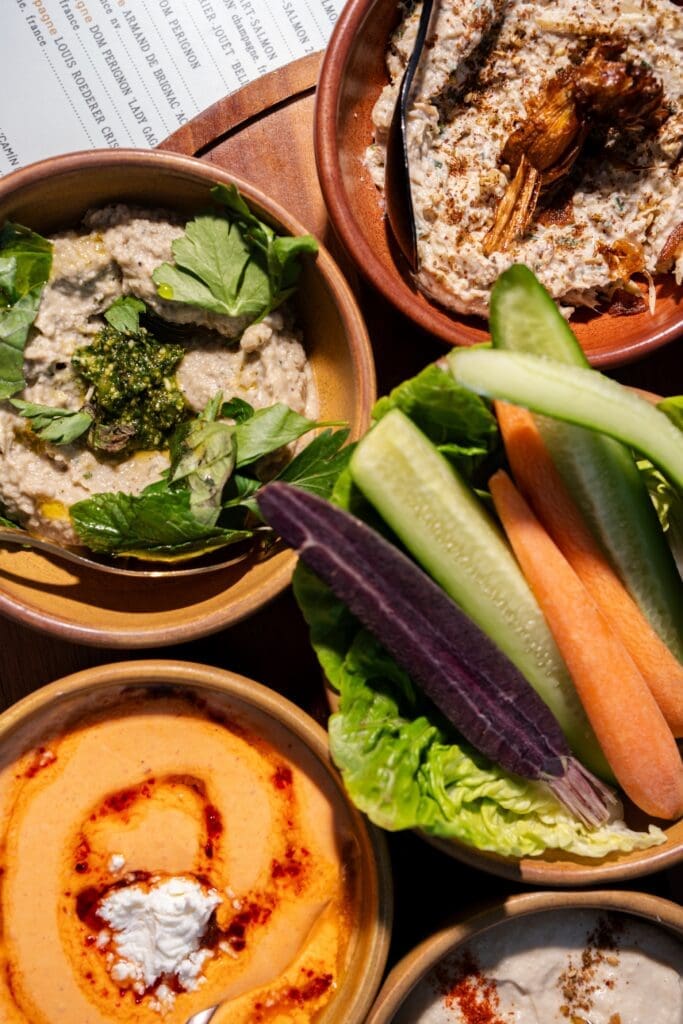 Close-up of Mediterranean dips with vegetables and herbs at Théa Rooftop restaurant.