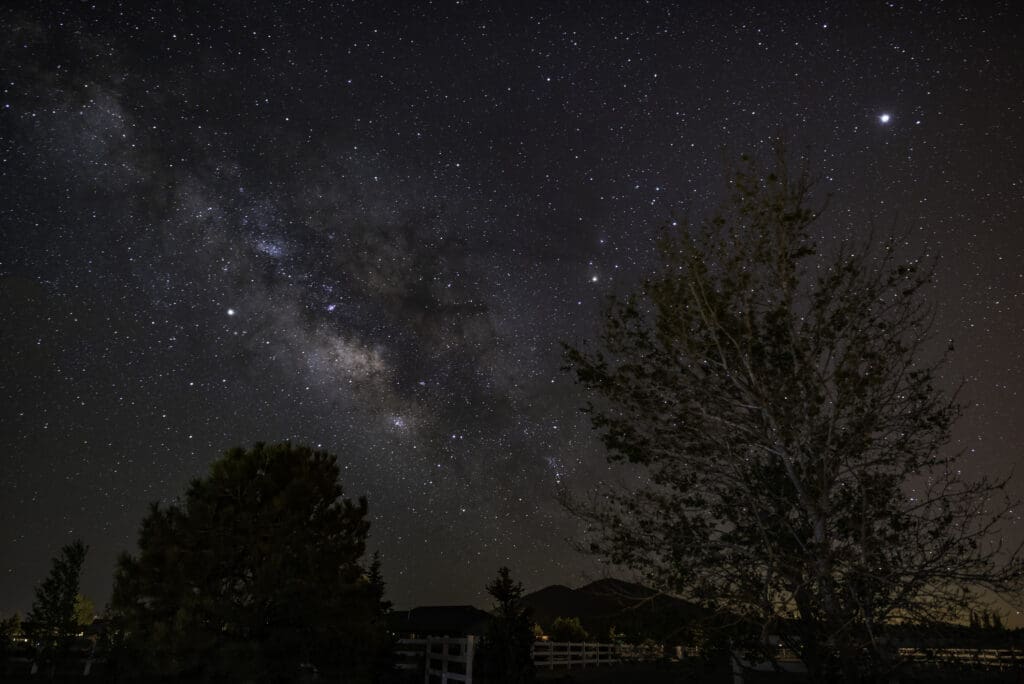 Milky Way visible over trees in Flagstaff Arizona dark sky city night sky.