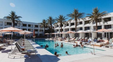 Outdoor pool scene at Hotel Solaya Scottsdale with cabanas lounge chairs and guests swimming.
