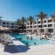 Outdoor pool scene at Hotel Solaya Scottsdale with cabanas lounge chairs and guests swimming.