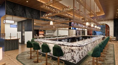Elevated marble bar with swivel bar chairs and gold, liquor interior design element at Jack's Modern Steakhouse Lone Tree.