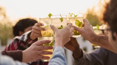 LombardoHappy multiethnic friends having fun cheering with Kentucky Derby cocktails outdoors.