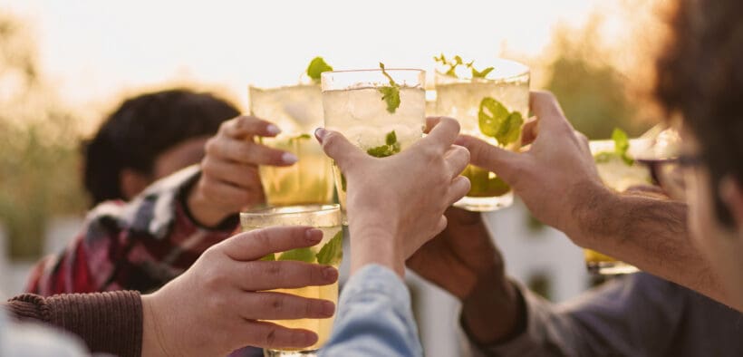LombardoHappy multiethnic friends having fun cheering with Kentucky Derby cocktails outdoors.