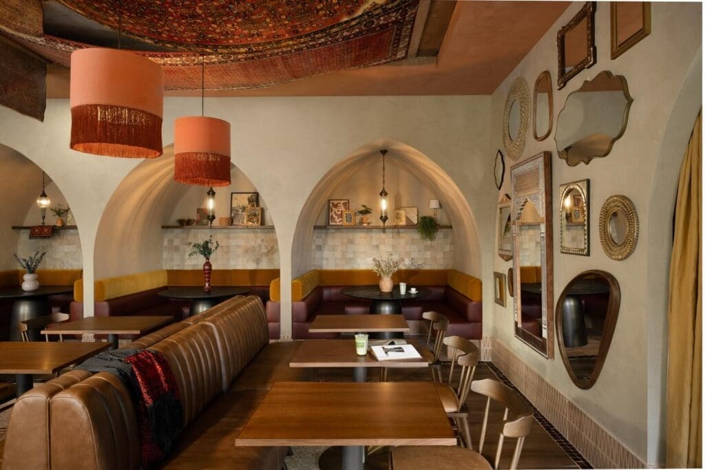 Warm café interior with arched seating, patterned ceiling decor and cozy booths at Laymoon Café in Tempe.