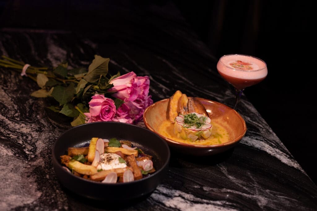 Colorful dishes and cocktails at Lumi rooftop restaurant in San Diego featuring Japanese-inspired cuisine and vibrant presentation.