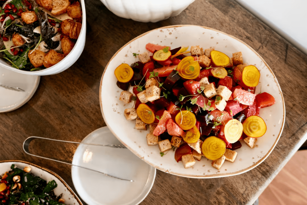 A bowl of sliced veggies and another small salad bowl with serving utensils at Park Hyatt Aviara.