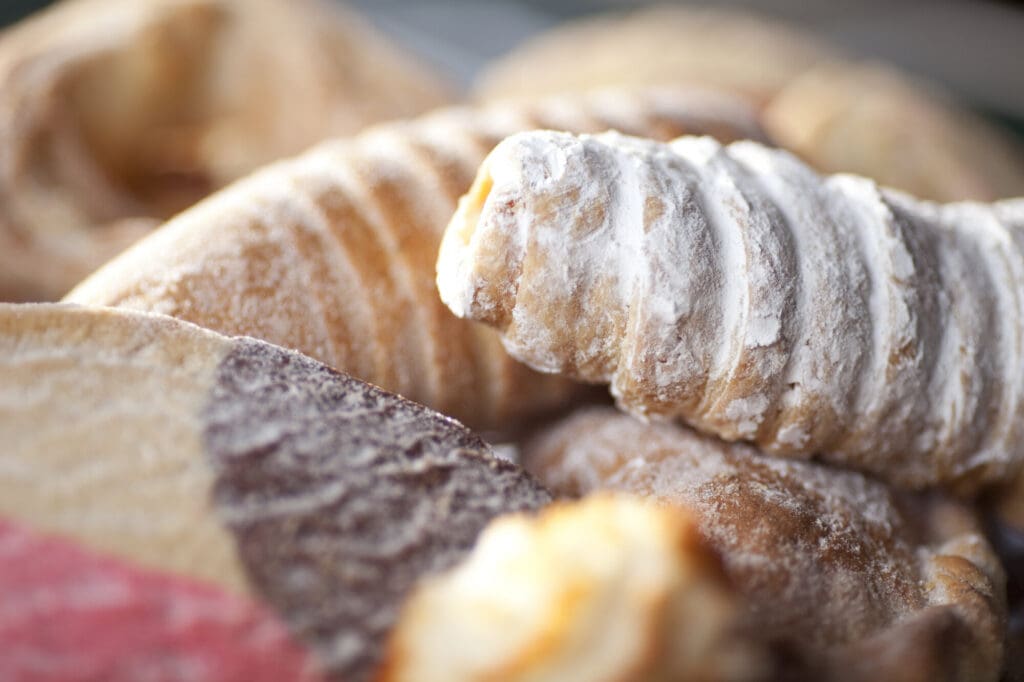 An assortment of Mexican pastries including conchas dusted with powdered sugar at El Paso bakery.