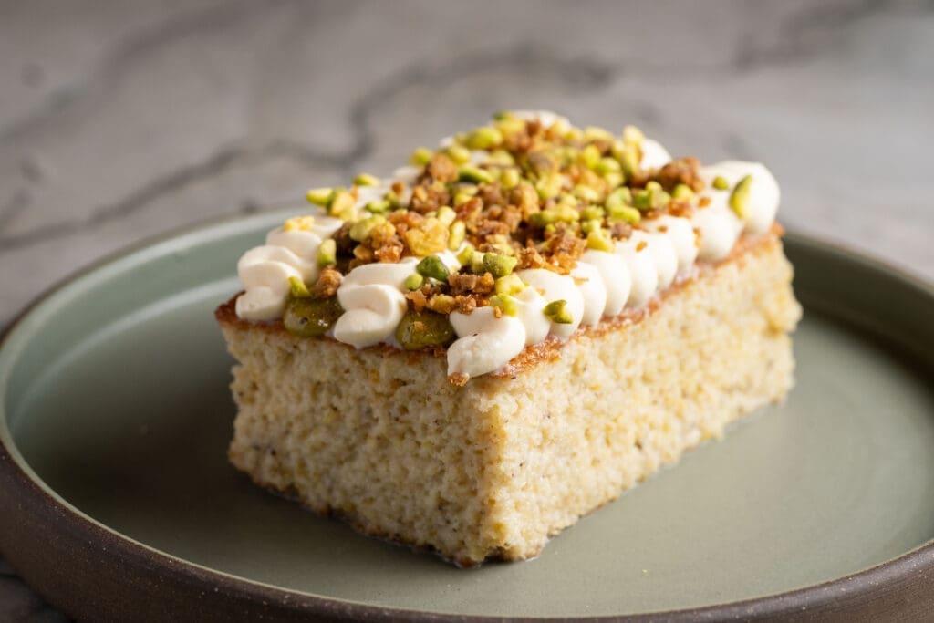 Pistachio tres leches cake from Puesto in San Diego topped with cream and crushed pistachios.
