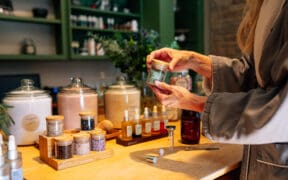 Guest creating custom body scrub with botanical ingredients at L’Apothecary Spa at L’Auberge de Sedona in Sedona Arizona.