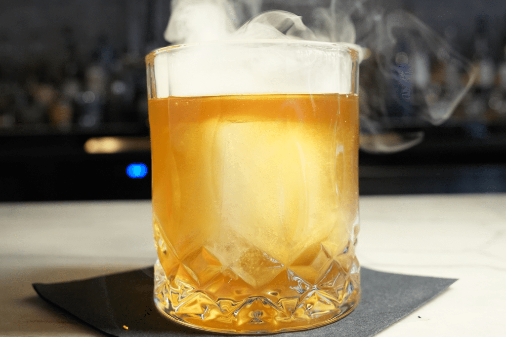 Craft Soft N' Smokey cocktail at Jack’s Modern Steakhouse Lone Tree with smoke drifting up from the cocktail glass.