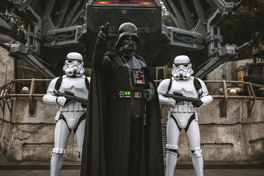 Darth Vader with Imperial Stormtroopers at Star Wars: Galaxy’s Edge in Disneyland, posing in front of First Order staging area.
