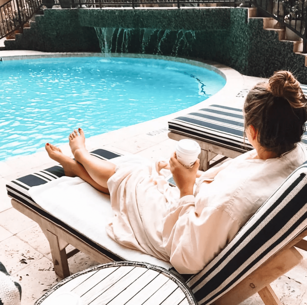 Guest relaxing poolside in a robe at Hotel ZaZa in Houston, Texas.