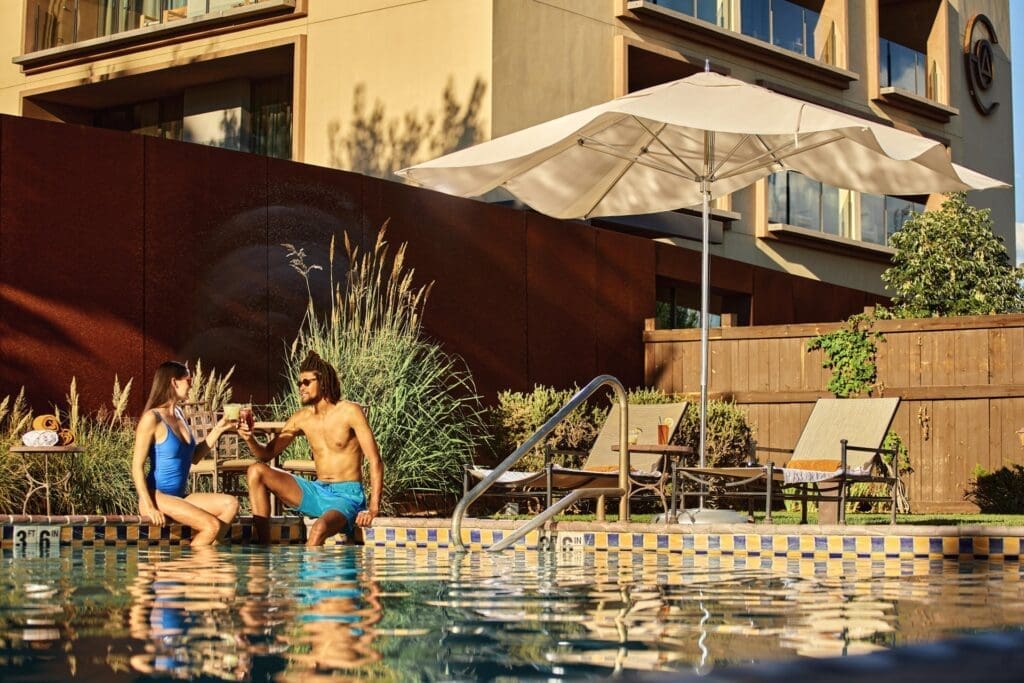 Couple relaxing beside the pool at Hotel Chaco in Albuquerque, New Mexico, during a summer staycation.