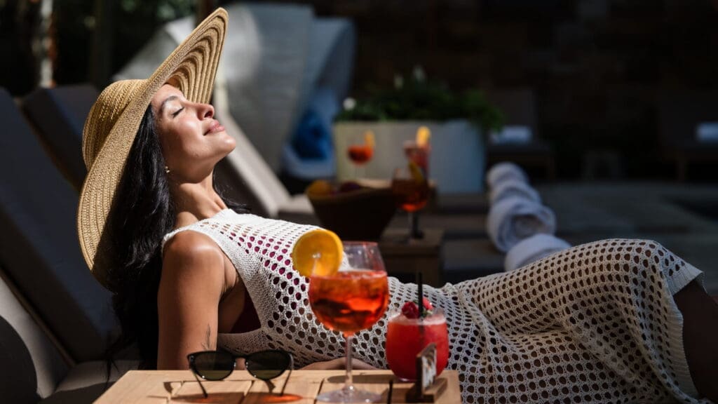 Guest relaxing poolside with cocktails at Four Seasons Resort and Residences Vail in Colorado.
