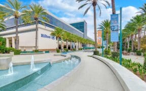 Exterior view of Hilton Anaheim with palm trees, fountain and resort entrance near Disneyland Resort in Anaheim, California.