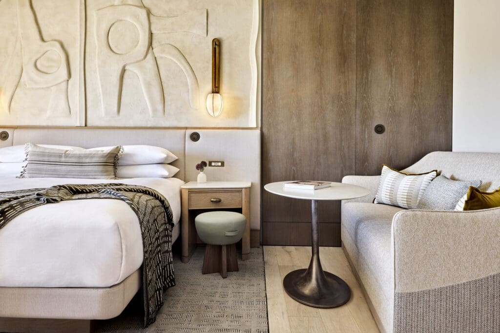 Modern guest room at JW Marriott Tucson Starr Pass Resort & Spa featuring neutral desert-inspired decor, a plush bed, sitting area and contemporary Southwest design details.