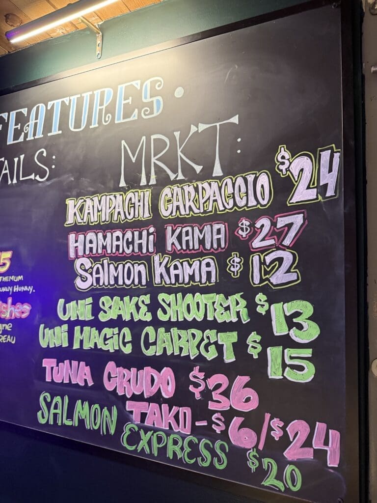 Across the Pond’s rotating MRKT board with block letters featuring limited-time seafood specials.