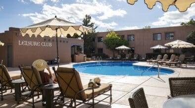 Pool area and lounge chairs at Hotel Glorieta in Santa Fe, New Mexico on a sunny afternoon.