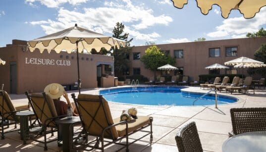 Pool area and lounge chairs at Hotel Glorieta in Santa Fe, New Mexico on a sunny afternoon.