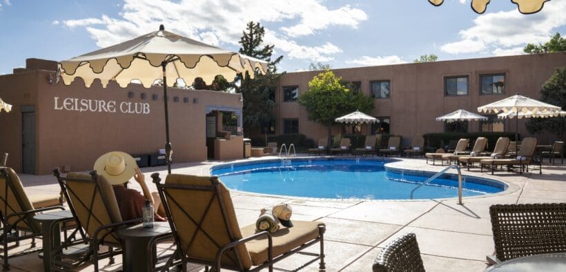 Pool area and lounge chairs at Hotel Glorieta in Santa Fe, New Mexico on a sunny afternoon.