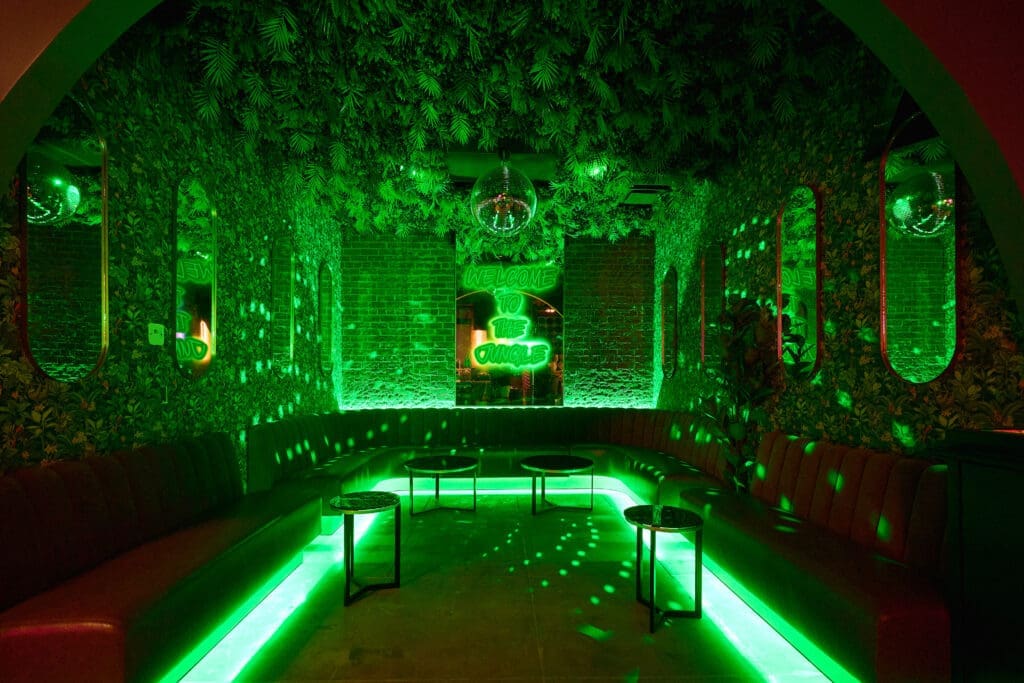 Neon green lounge area inside Off The Record singalong bar in Phoenix.