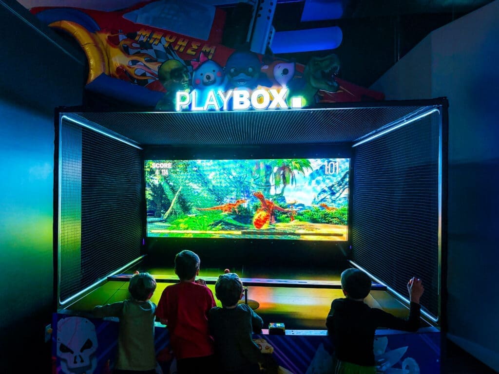 Children playing an interactive digital game inside the Playbox attraction at Immersive Empire.
