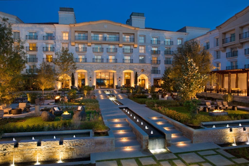 Exterior evening view of Signia by Hilton La Cantera Resort & Spa in San Antonio, Texas, featuring landscaped grounds and illuminated water features.