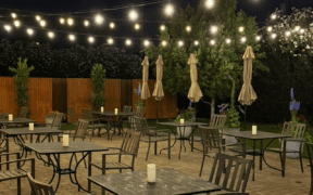 Outdoor patio dining at Quiessence in Phoenix with string lights and candlelit tables at night.