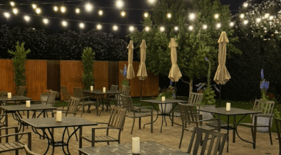 Outdoor patio dining at Quiessence in Phoenix with string lights and candlelit tables at night.