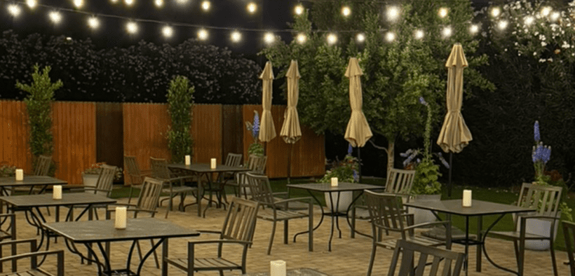 Outdoor patio dining at Quiessence in Phoenix with string lights and candlelit tables at night.