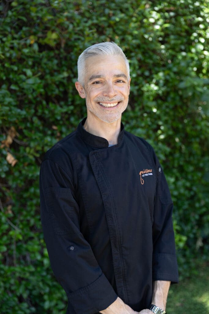 Chef Dustin Christofolo of Quiessence at The Farm at South Mountain standing outdoors in chef coat.