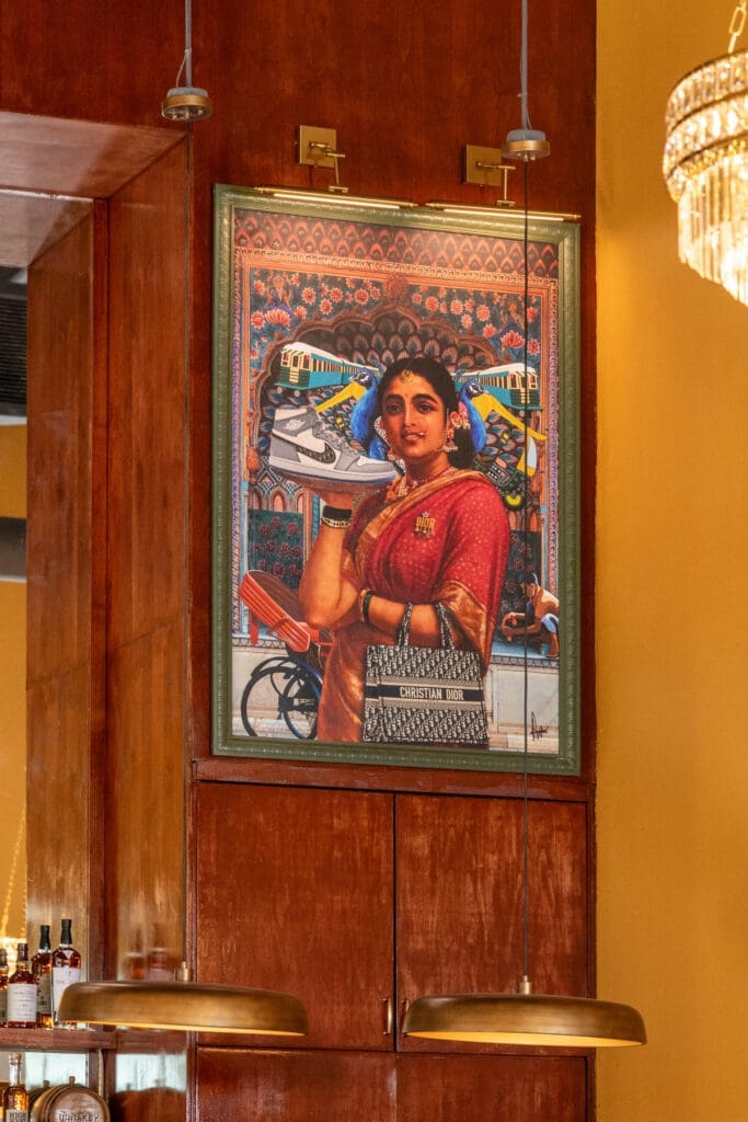Contemporary portrait artwork inside NADU Phoenix featuring a woman in traditional Indian attire with modern fashion elements displayed above the restaurant's bar.
