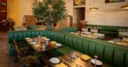 Curved green booth seating and contemporary dining room at NADU Phoenix inside Desert Ridge Marketplace.