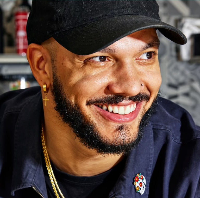 Chef LT Smith smiles in a portrait photograph after being named to the James Beard Foundation's 2026-27 TasteTwenty class.