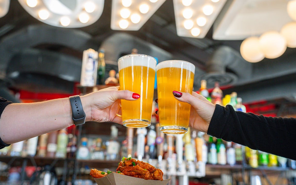 Two people toast beers at Denver Milk Market during Fourth of July celebrations in downtown Denver.