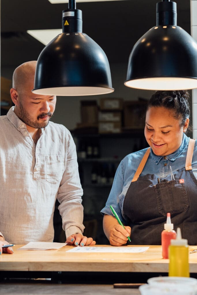 Chefs Evelyn Garcia and Henry Lu review notes together inside the kitchen at JŪN in Houston.