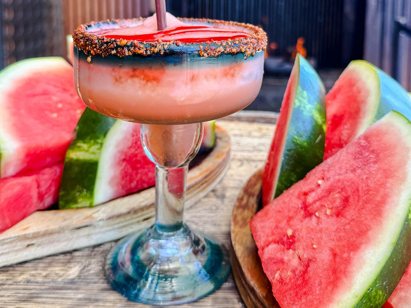 Frozen watermelon margarita with a chili-rimmed glass surrounded by fresh watermelon slices at Federales in Denver's RiNo neighborhood.