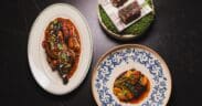 Signature dishes from Pompette and Little Rich Girl displayed on a table, including roasted chicken, Wagyu skewers and a composed entrée in downtown Flagstaff.