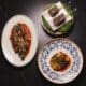 Signature dishes from Pompette and Little Rich Girl displayed on a table, including roasted chicken, Wagyu skewers and a composed entrée in downtown Flagstaff.