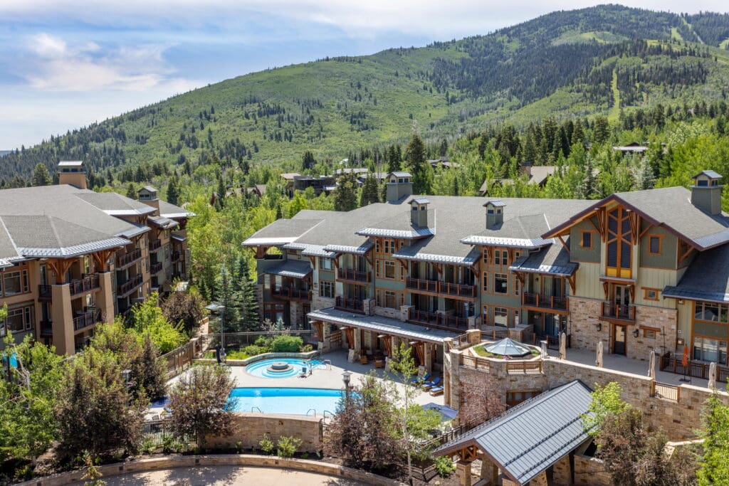 Exterior view of Hyatt Centric Park City surrounded by mountain landscapes and alpine lodging.