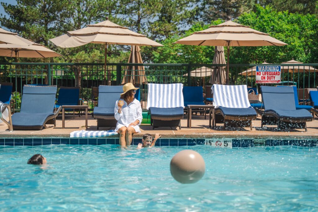 Guests relax at the outdoor pool at Inverness Denver during a summer holiday weekend.