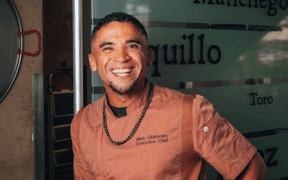 Chef Marc Quiñones smiles while standing inside La Fonda on the Plaza in Santa Fe, New Mexico.
