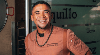 Chef Marc Quiñones smiles while standing inside La Fonda on the Plaza in Santa Fe, New Mexico.