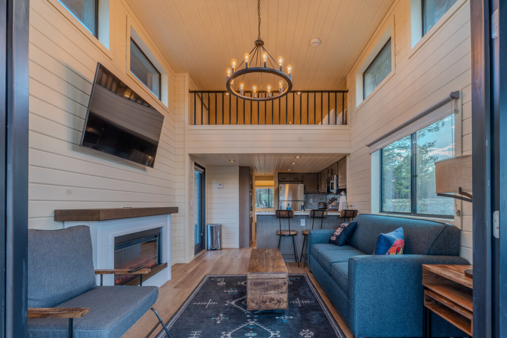 Guests seated inside the Village Camp Flagstaff clubhouse with large windows overlooking the outdoor resort.
