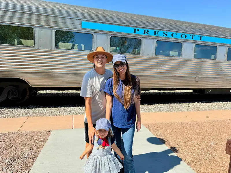 A family poses in front of a Verde Canyon Railroad passenger car before a Father's Day train excursion.