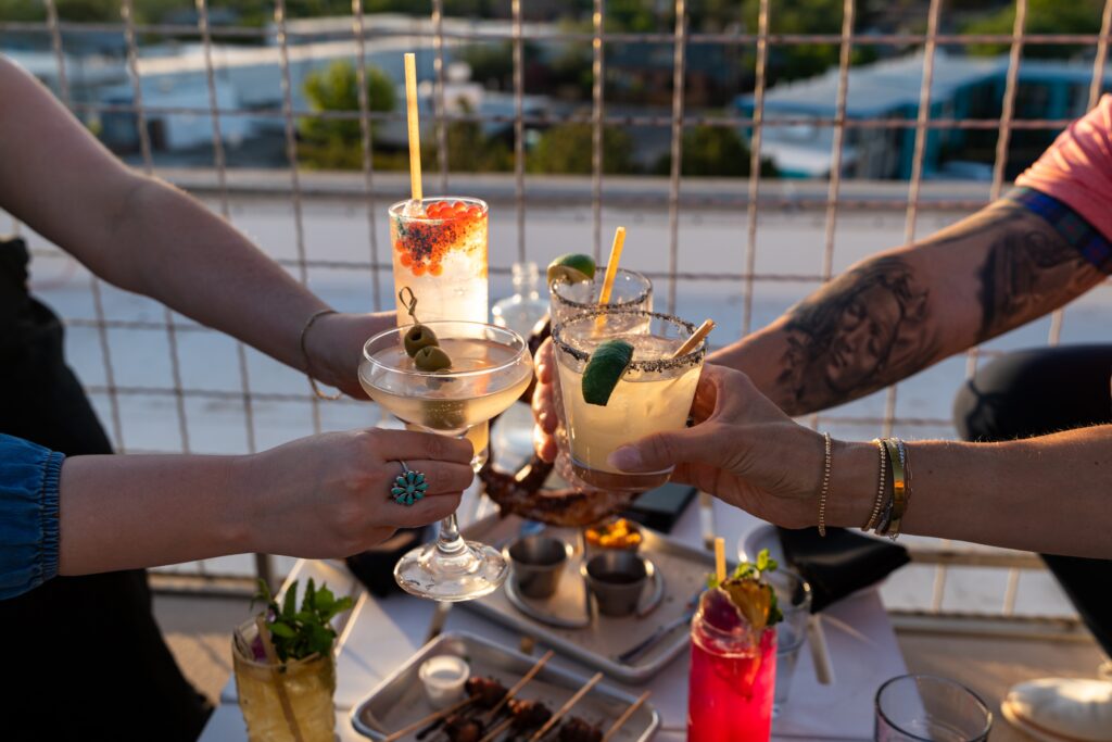 Guests enjoying handcrafted cocktails on the rooftop patio at Apothecary Lounge in Albuquerque.