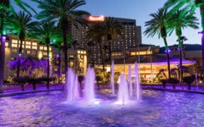 Harrah's Southern California Resort exterior at dusk with illuminated fountains and palm trees in Funner, California.