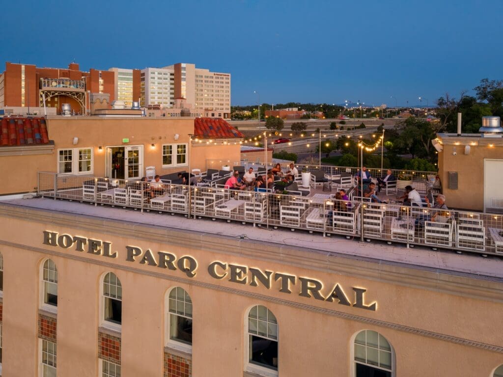Aerial view of Hotel Parq Central rooftop and Apothecary Lounge in Albuquerque at dusk.