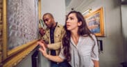 Two guests examine clues inside The Heist escape room at The Escape Game in Gilbert, Arizona.
